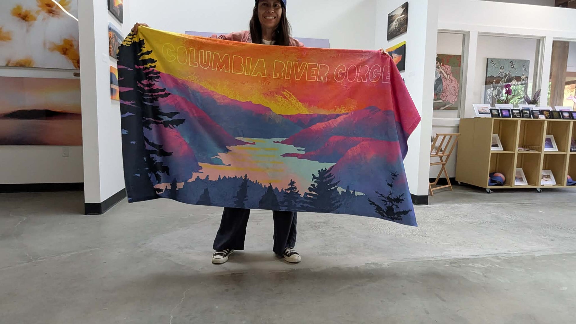 Artist Paloma Ayala holding the Columbia Gorge Beach Towel featuring the Moments of Magic fine art print by Orolume Gallery