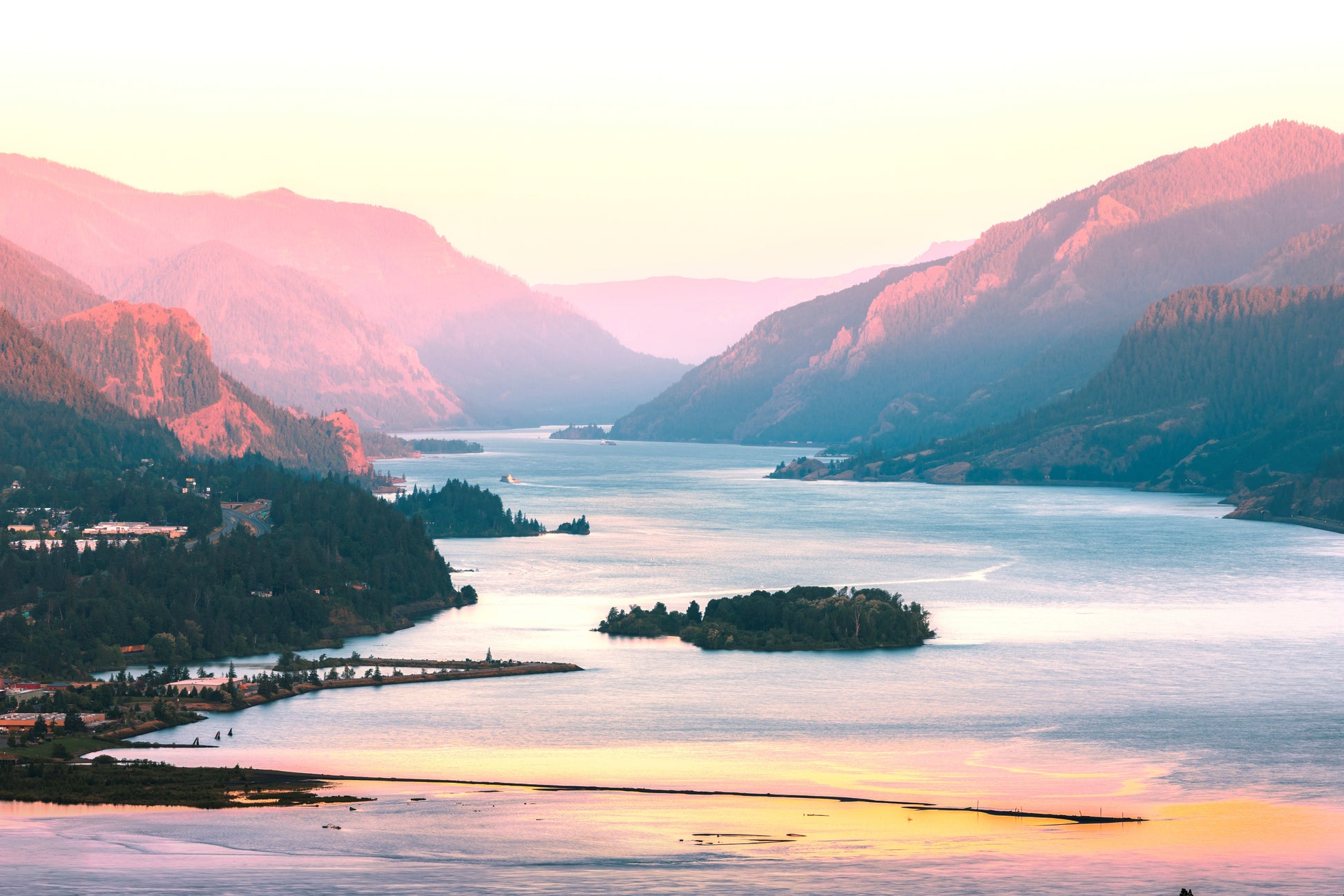 Columbia River Gorge near Hood River, Oregon, captured during a peachy sunrise, revealing the dramatic cliffs of the Gorge.