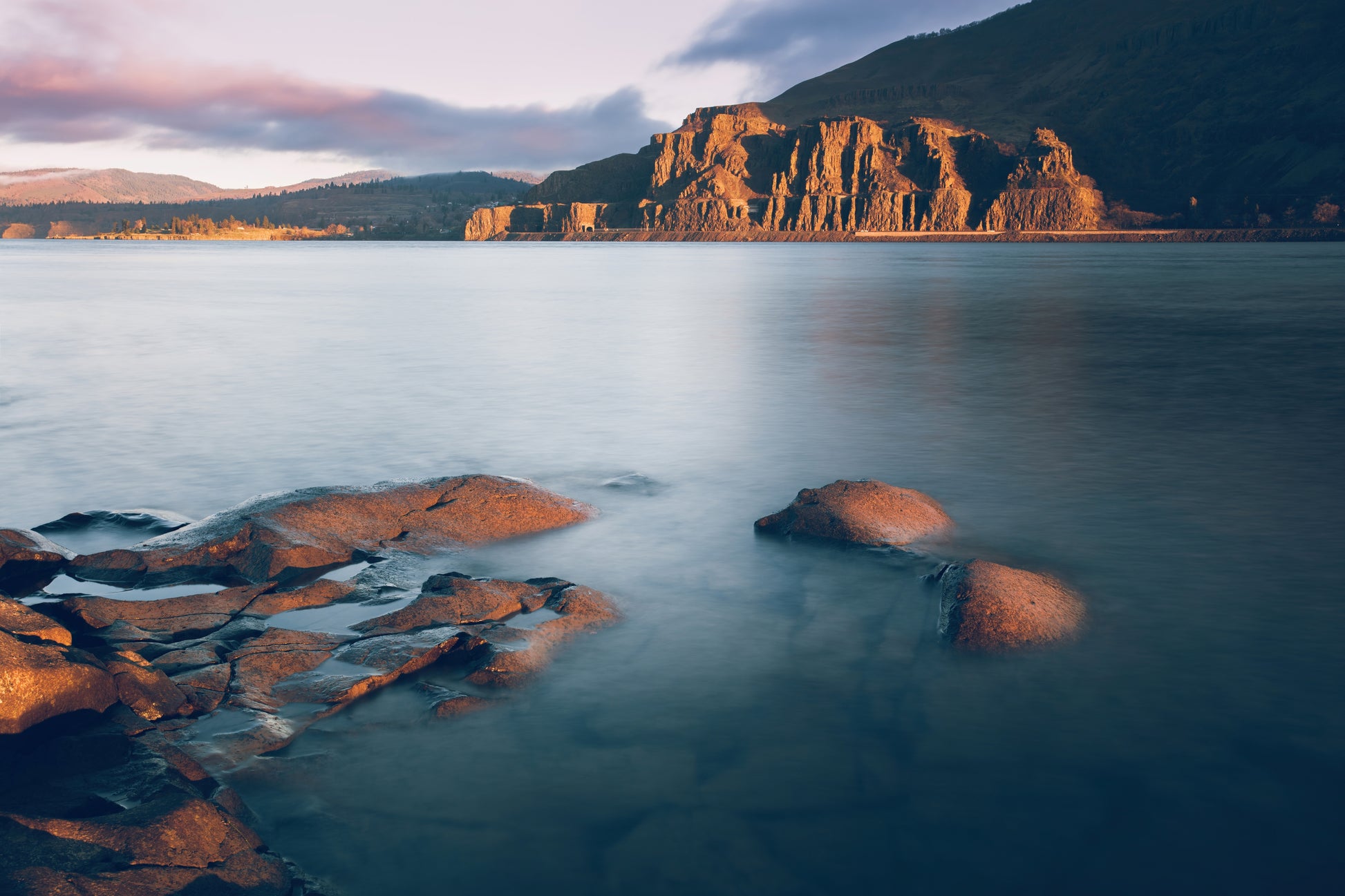 Columbia River rocky shoreline photography morning light. Cherry orchard trail in background. Oregon landscape print