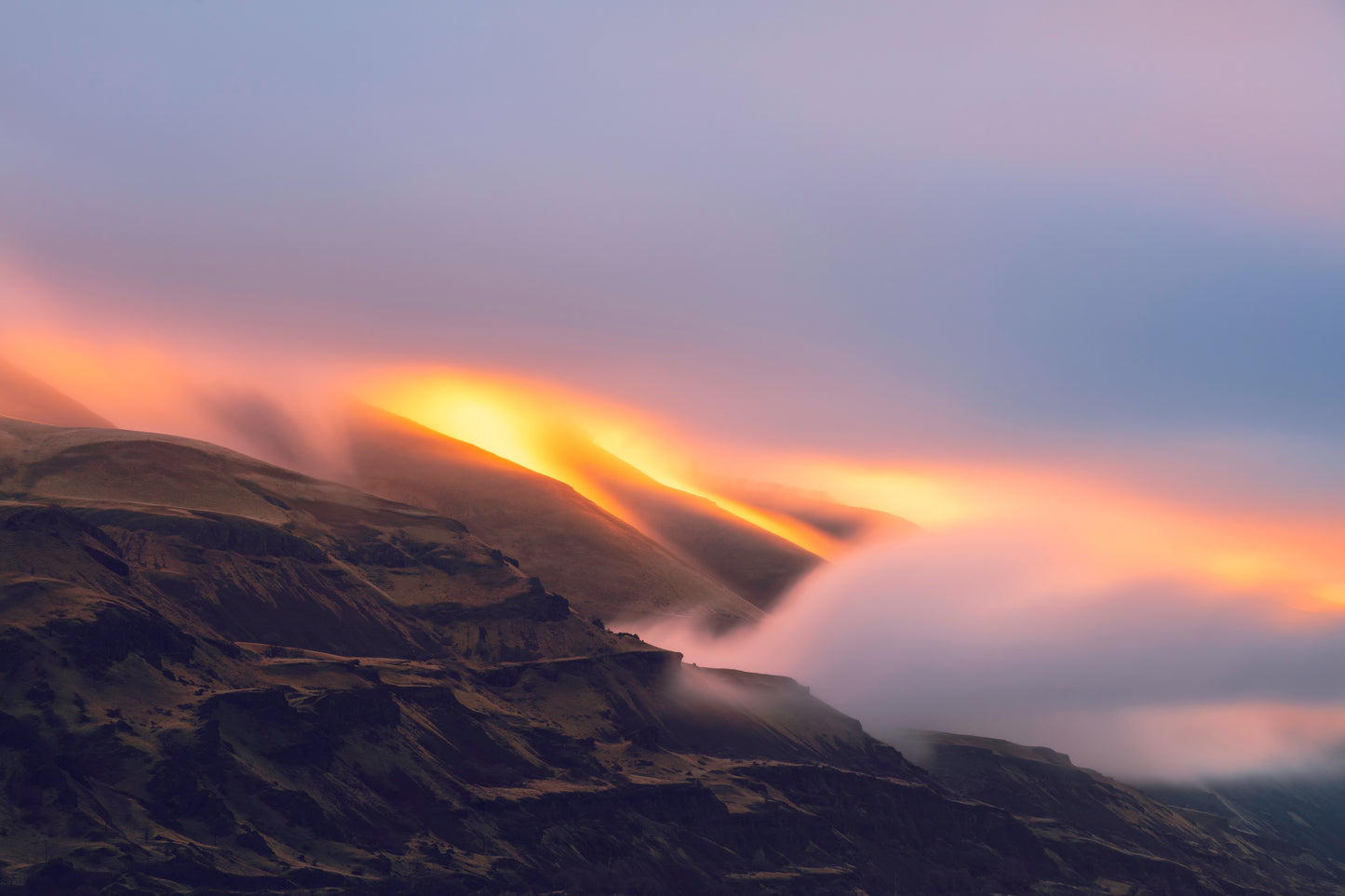 Hilly landscape with colorful light streaks in the sky